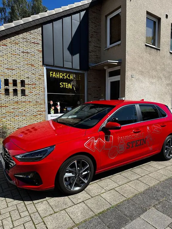 Zweites rotes Fahrschulauto der Fahrschule Stein vor dem Fahrschulbüro in Köln-Porz