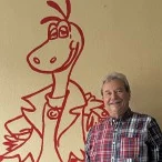 Ronald Stein, Senior-Chef der Fahrschule Stein, vor dem gemalten Drachen im Unterrichtsraum